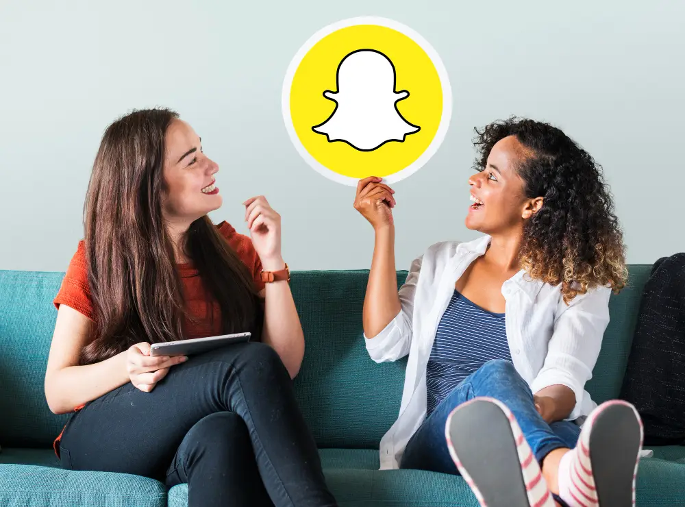 How-Snapchat-Works-The-Essential-Guide-for-Beginners-in-2023-young-women-showing-snapchat-icon